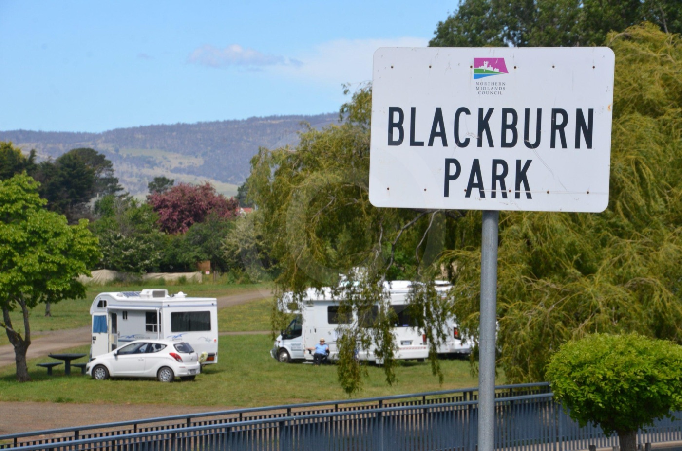 Cartello di Blackburn Park con camper sul prato, esempio di area di sosta in Tasmania