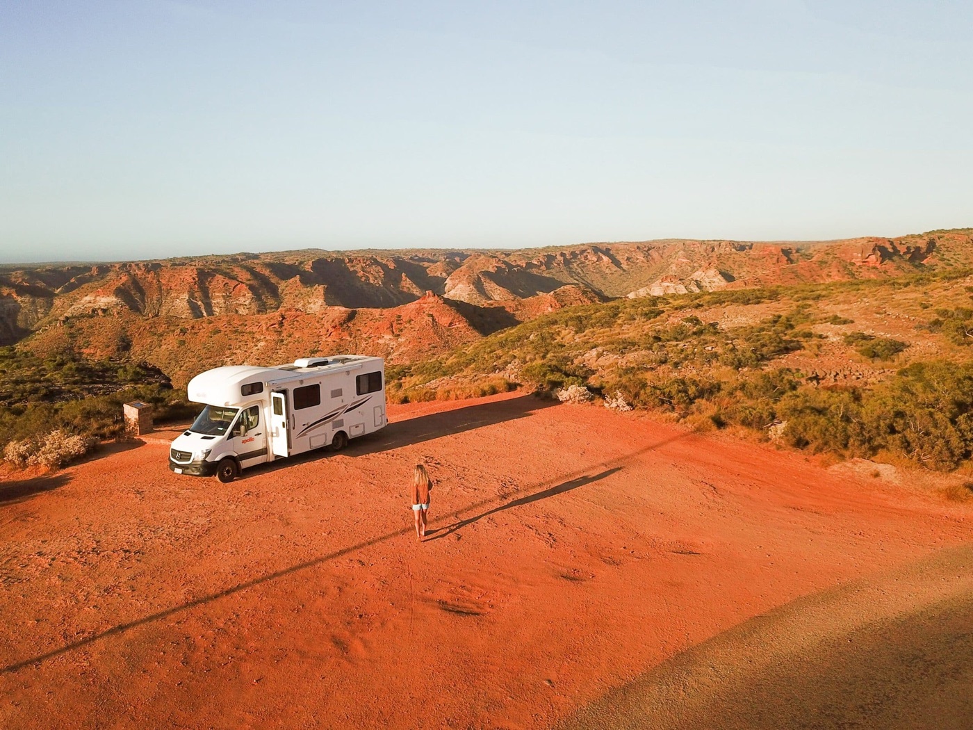 Camper grande su una pista rossa dell’outback, davanti a gole desertiche